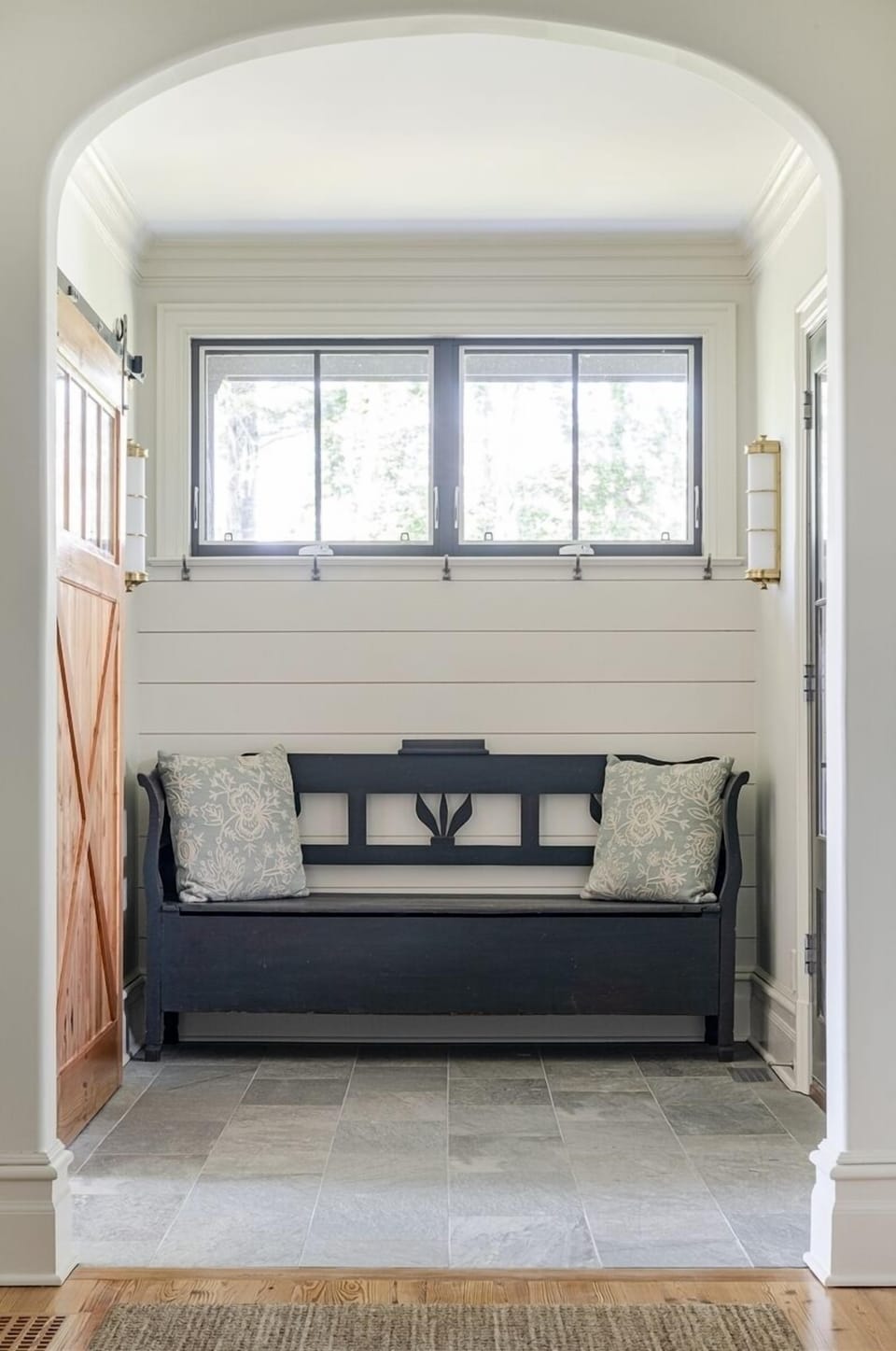 Side entrance hallway with sliding barn door leading to the television room.