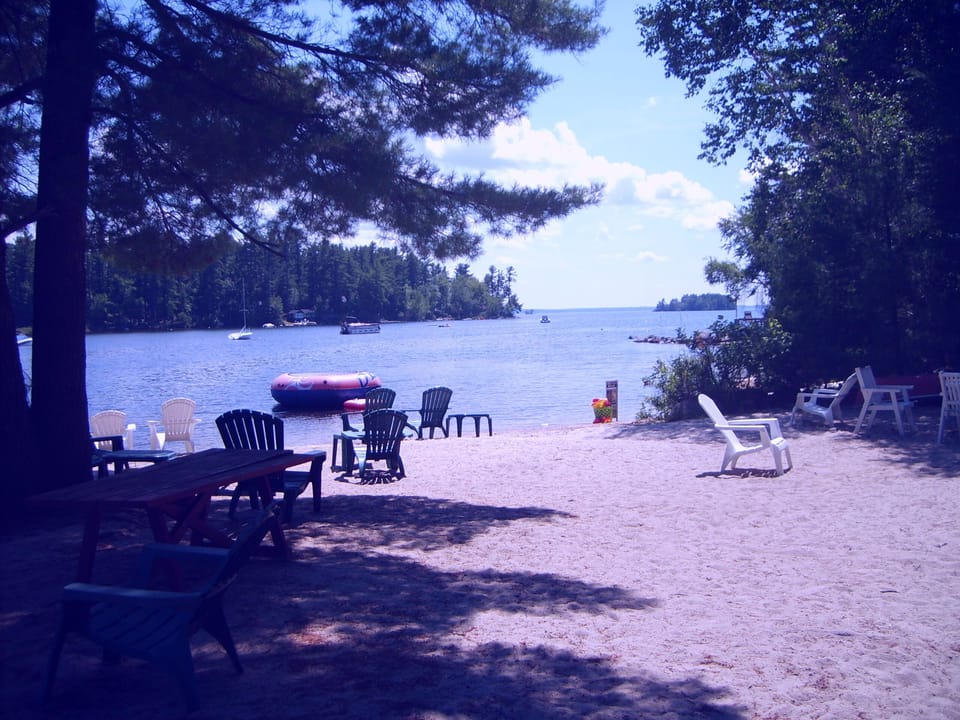Beach with some of supplied chairs and picnic tables.Dingley Islands can be seen