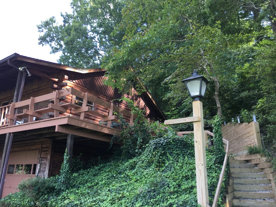 Front of house with stairs to get up to deck and covered porch.