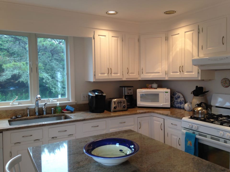 Remodeled kitchen includes granite counter-tops and center island.