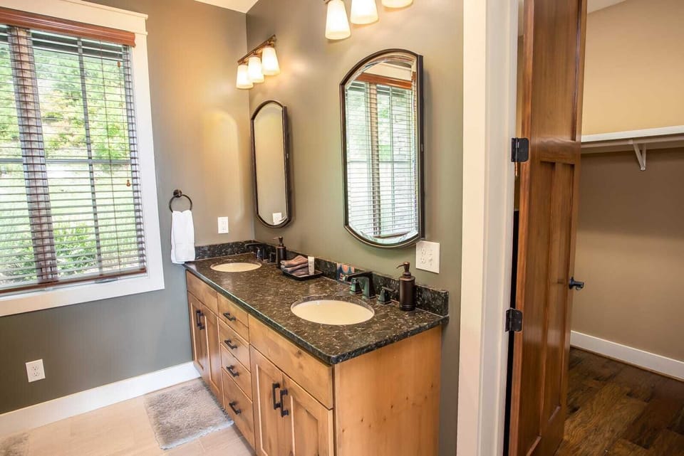 Main Level Master Bathroom has Granite Vanity with Double Sinks and Large Tiled Shower with Frameless Glass Door