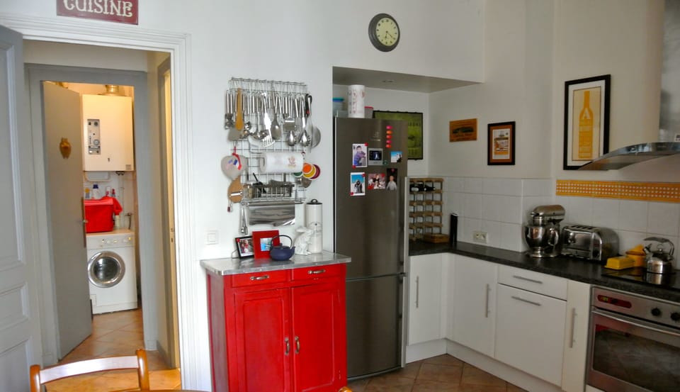 The kitchen is large and modern; through the door is the laundry room.