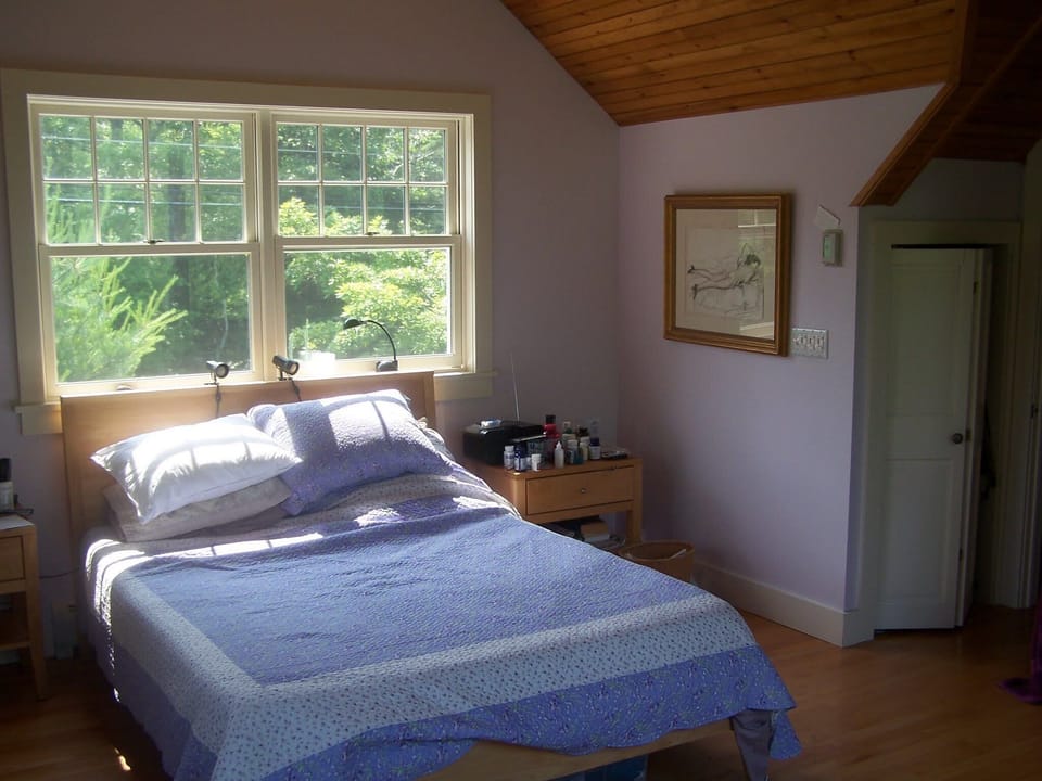 bedroom with queen size bed, windows all around the room facing mountain
