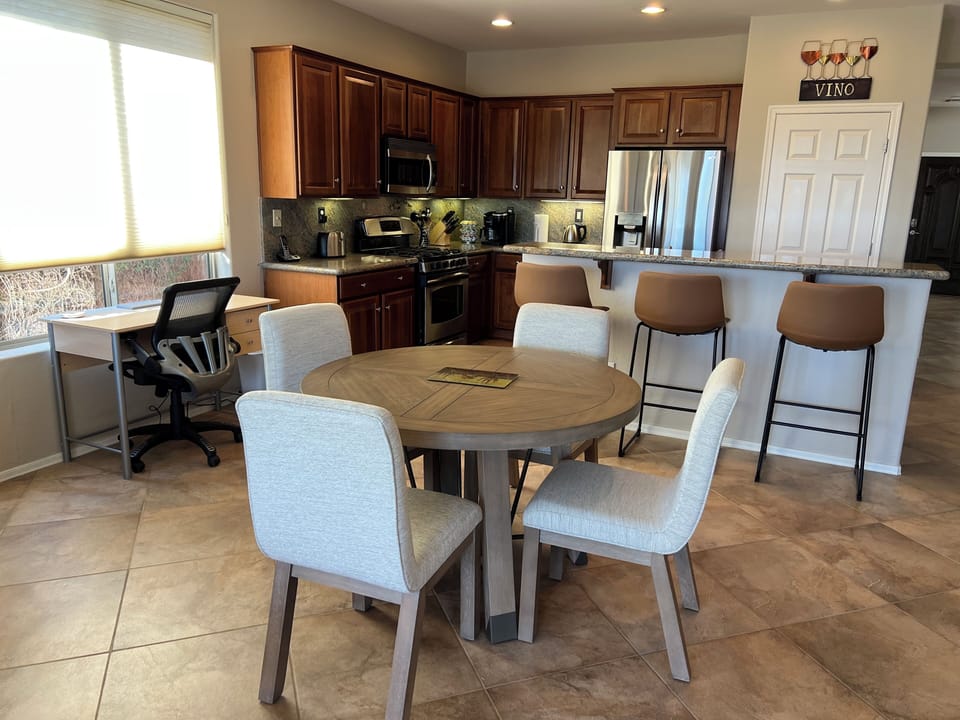 Dinette with seating for 4, plus 3 bar stools for extra seating.