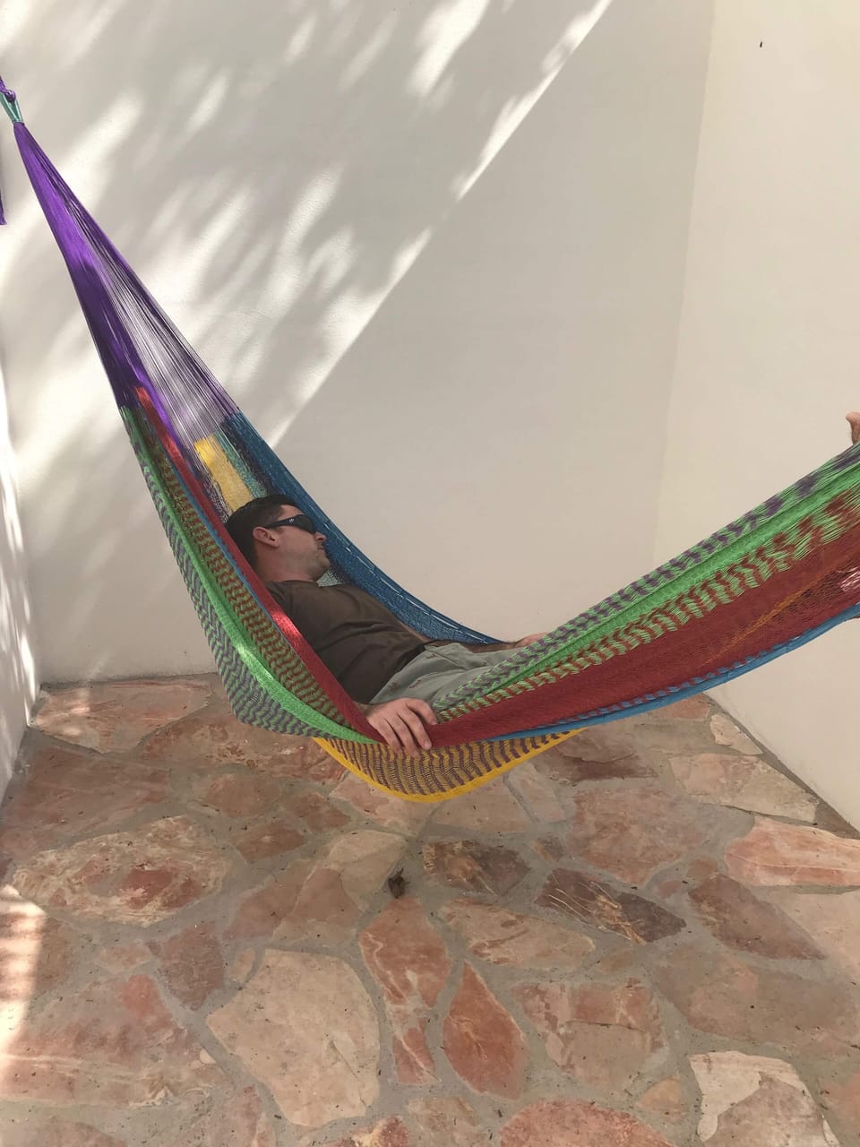 Private backyard sitting area with chairs, a table and two hammocks