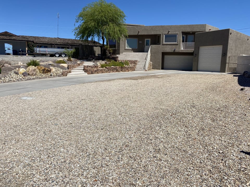 Huge driveway with gravel for parking all the toys. 40'x80'.