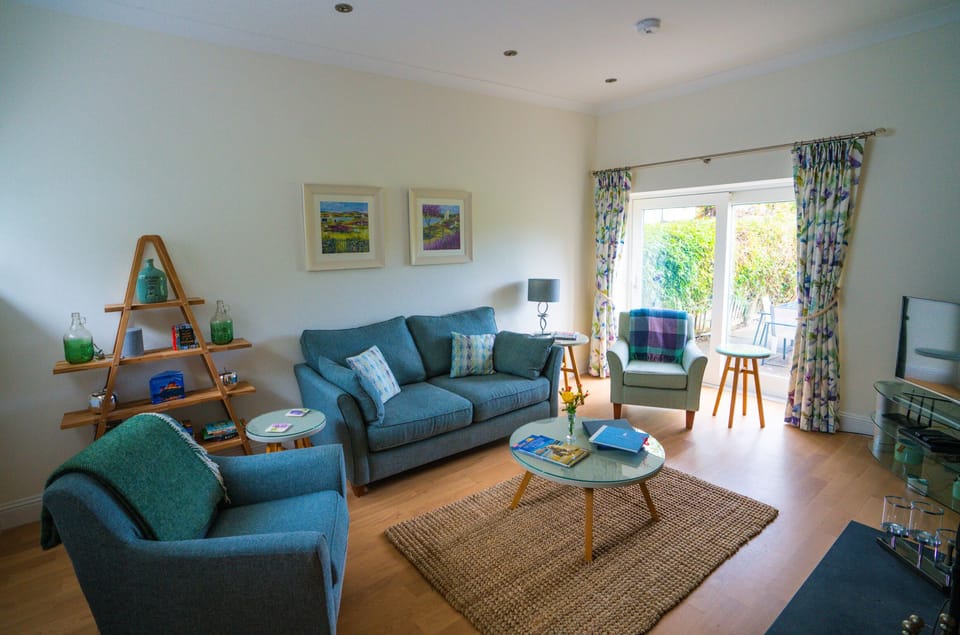 Fraser cottage living room with patio doors to patio area with outdoor table