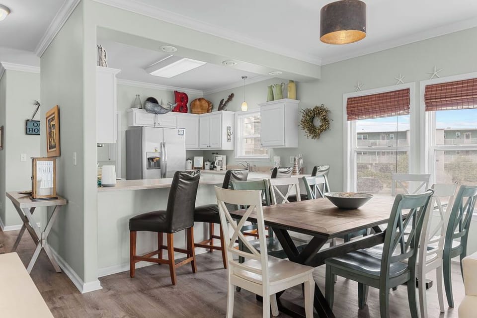 Dining Area - The spacious dining area features a table with seating for 8 with additional seats offered at the adjacent bar.