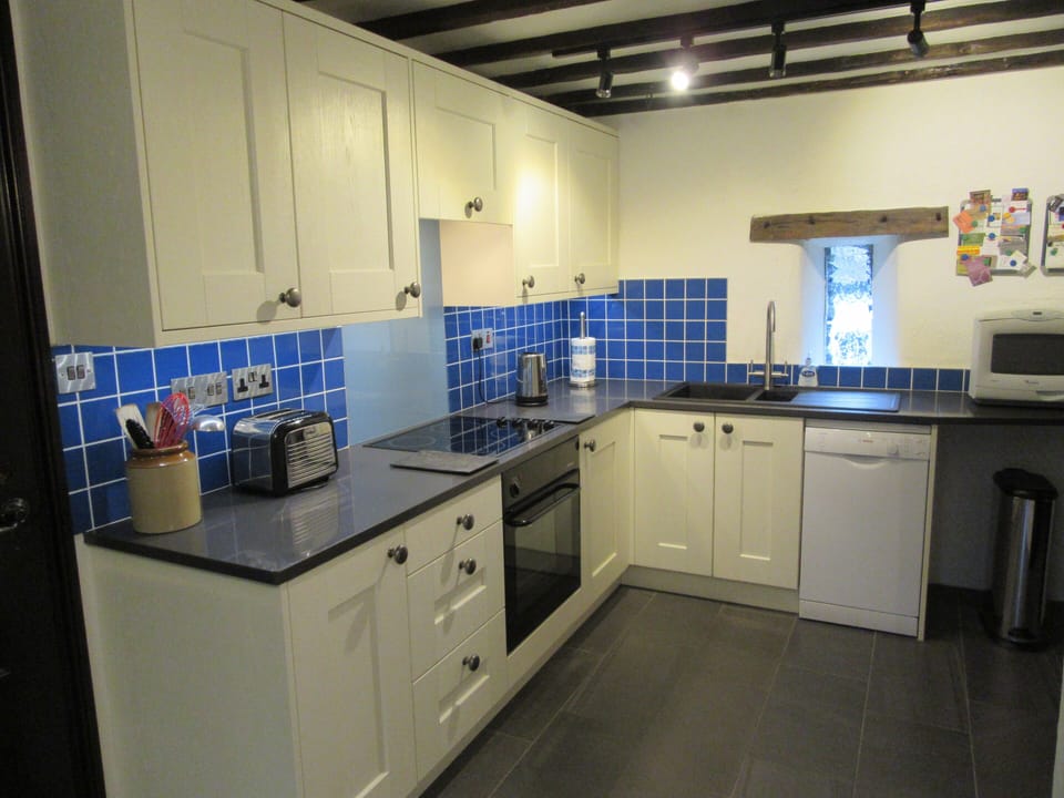 Kitchen with dishwasher, electric hob & oven, and underfloor heating.