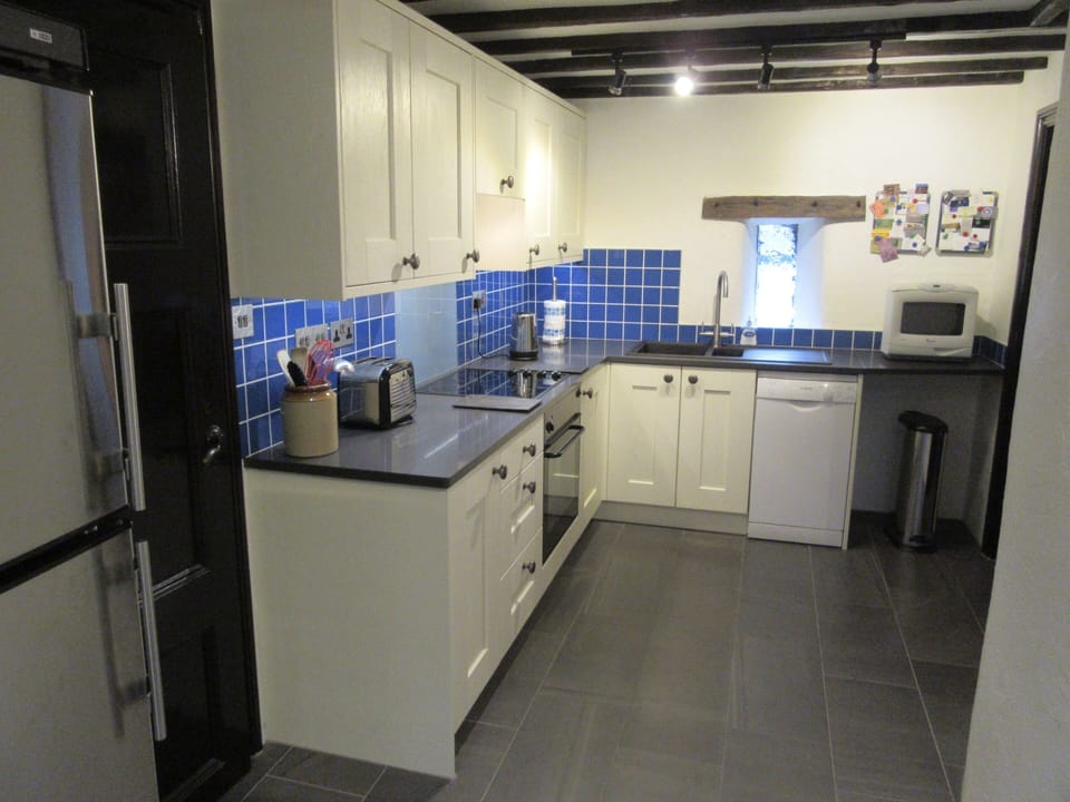 Kitchen with fridge/freezer, underfloor heating, hob, oven and microwave oven.