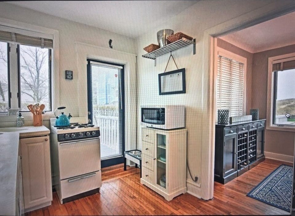 Kitchen with doorway to deck with gas Weber grill