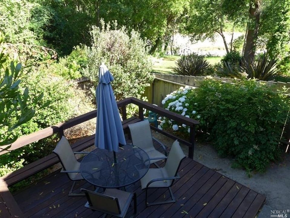 Fenced Back Yard with deck of Cottage #4, looking out to the river