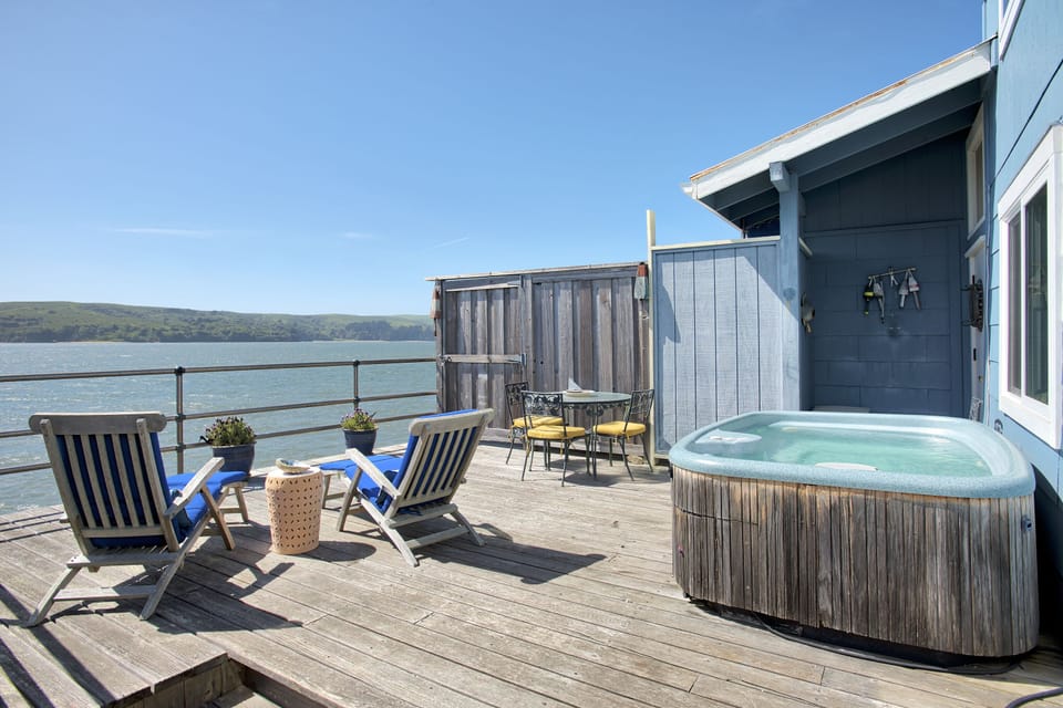 Large private bayfront deck with hot tub and lounge chairs