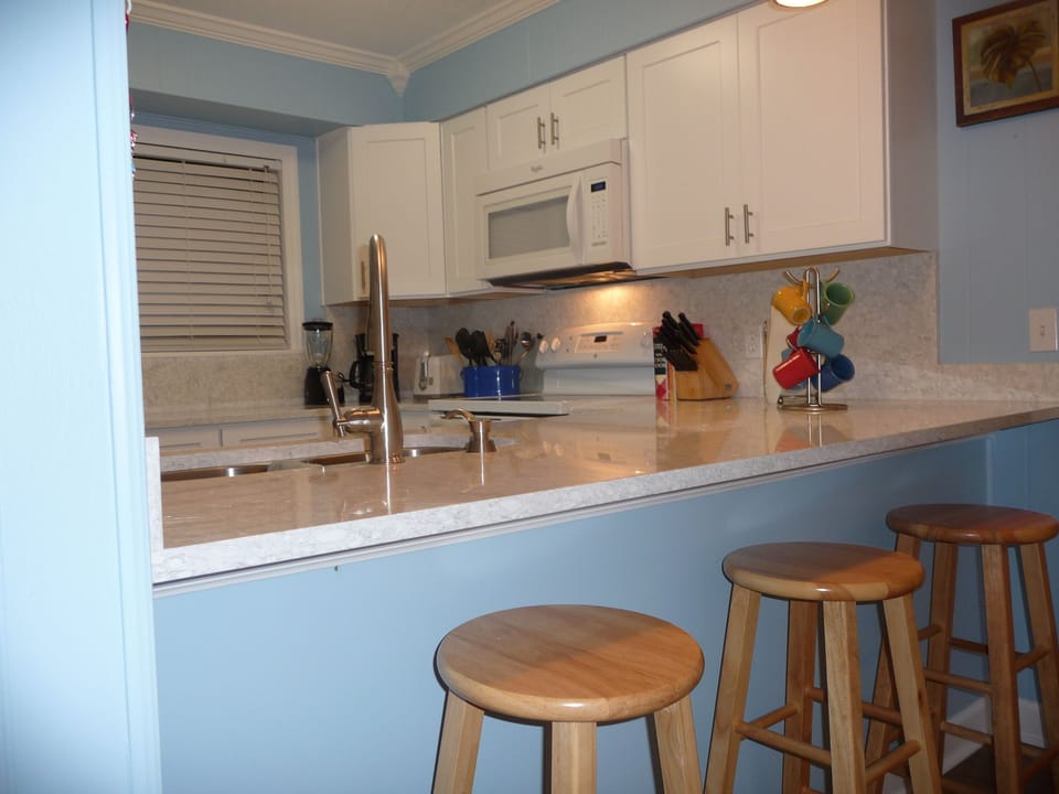 Kitchen has bar seating for three