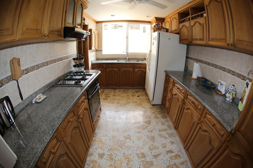 Kitchen Area with large Refrigerator and granite counters.