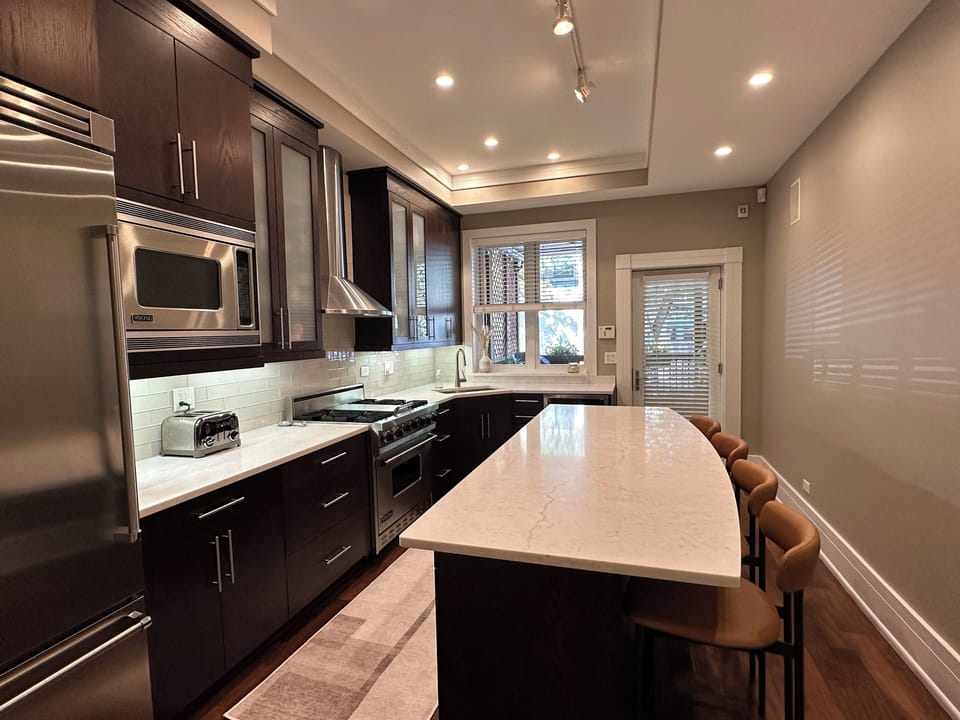 Well appointed kitchen leads to deck and secured parking area beyond.