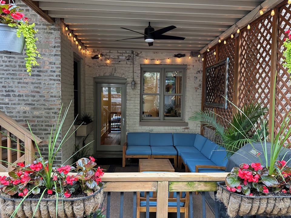 Porch/deck has rain cover, ceiling fan, Weber grill, and festive lighting.