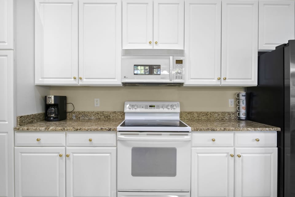 69 Willow Oak Ave - Kitchen Detail and Cabinetry - The kitchen's linear layout maximizes efficiency, offering generous counter space for meal preparation. Recessed lighting and high ceilings make the area feel spacious and well-lit, making it a functional hub for the home.