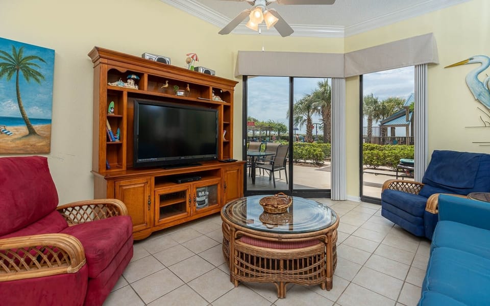 Relax in the inviting living area, featuring a TV, sofa with queen sleeper, and views of the outdoor patio