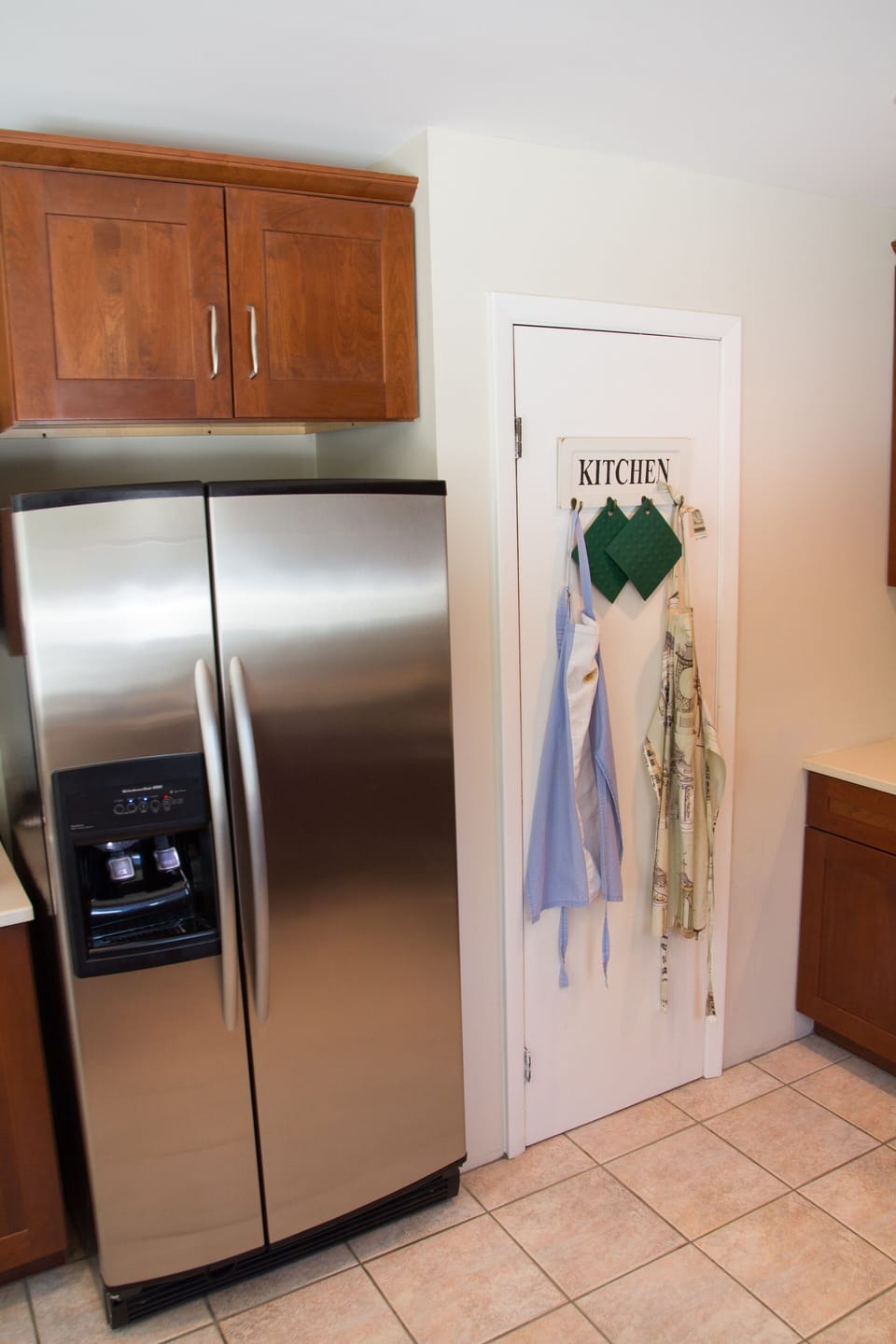 A spacious refrigerator/freezer and pantry occupy on side of the large kitchen.