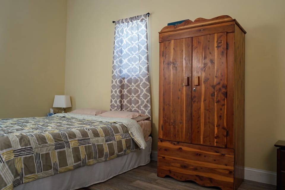 Armoire with hangars, iron, and ironing board for wrinkle free clothing.