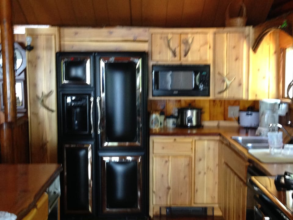 Kitchen Refrigerator, and custom cedar cabinets with antler handles.