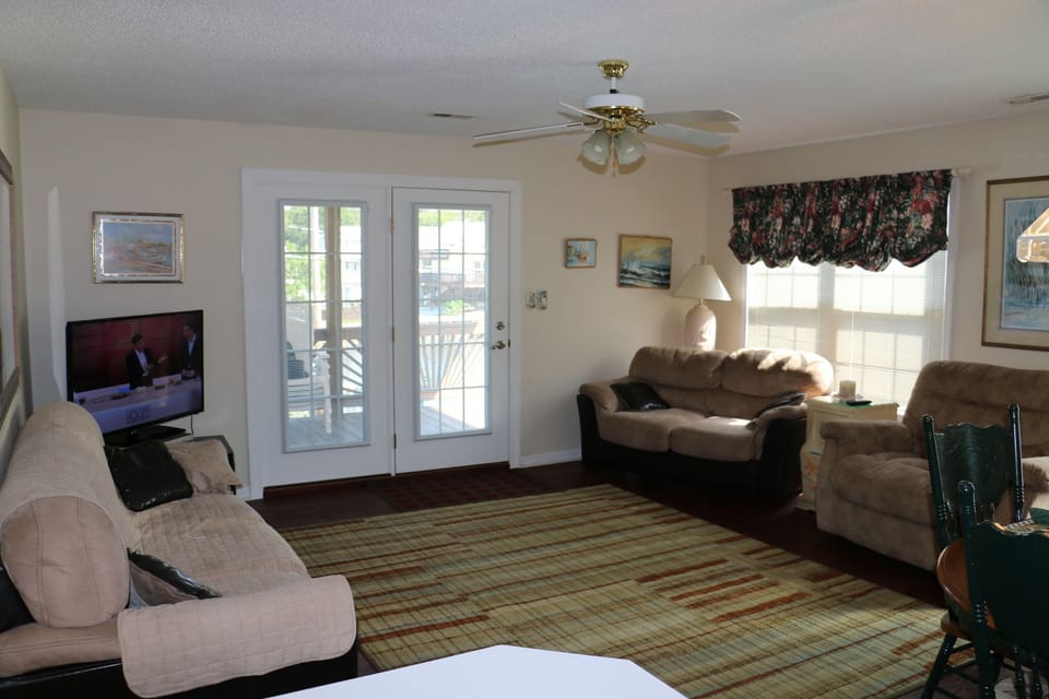 Open living room has 2 doors leading to outside deck 