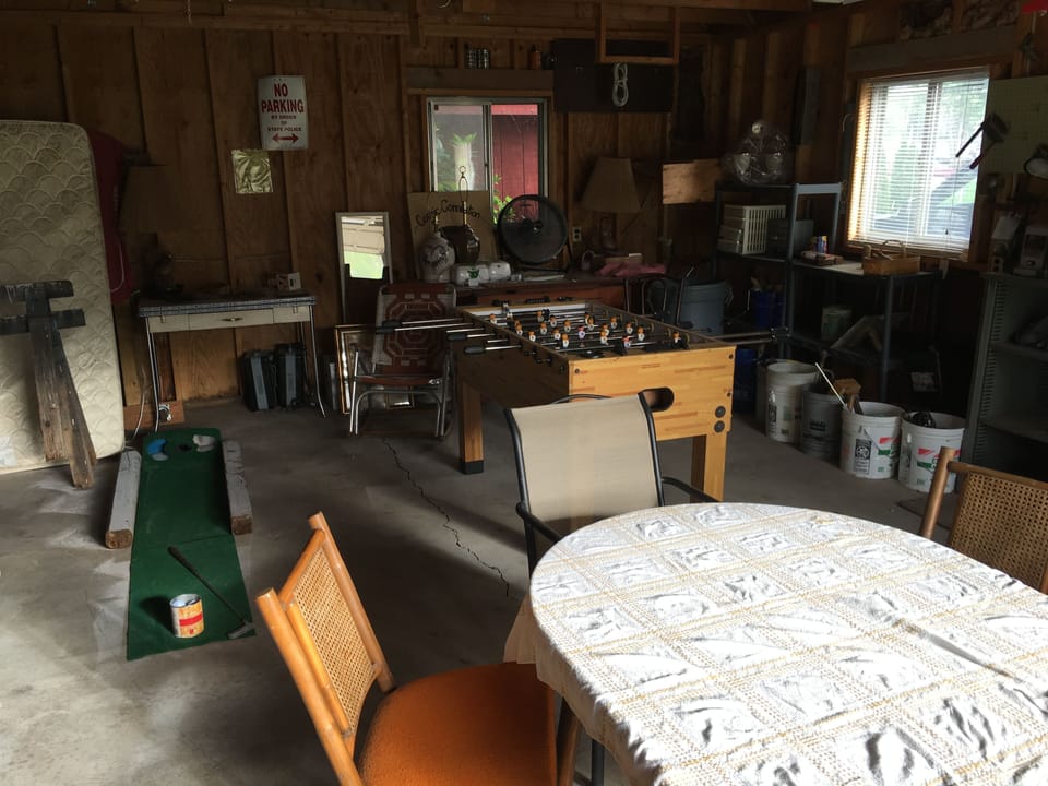 Garage has screen door, Foosball, Putting Green, table and chairs.