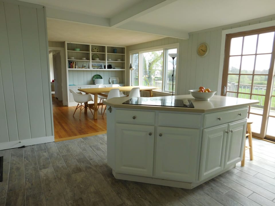 View from kitchen back to dining area. Sliding glass door on right opens to deck