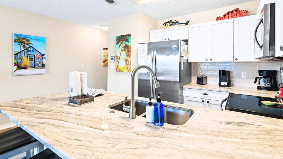 An open kitchen with a granite island and bar seating.