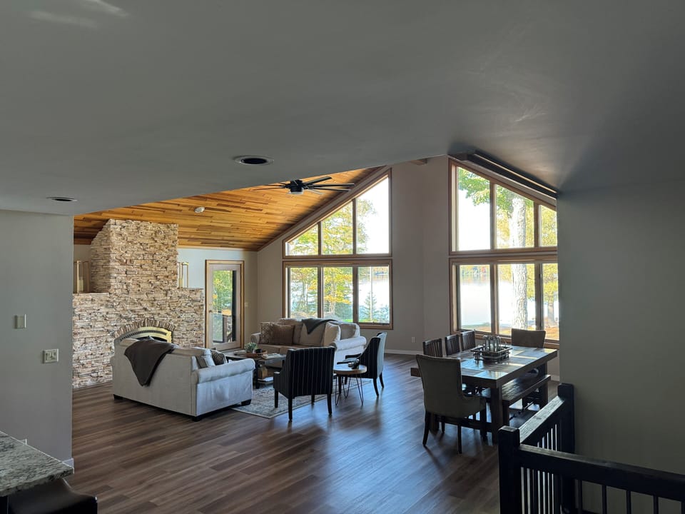 Large open main living area! Stone fireplace and windows overlooking the lake. 