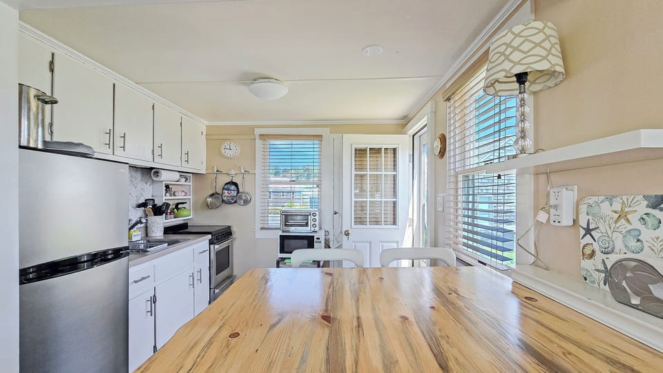 Dining table with seating for four and nicely equipped kitchen