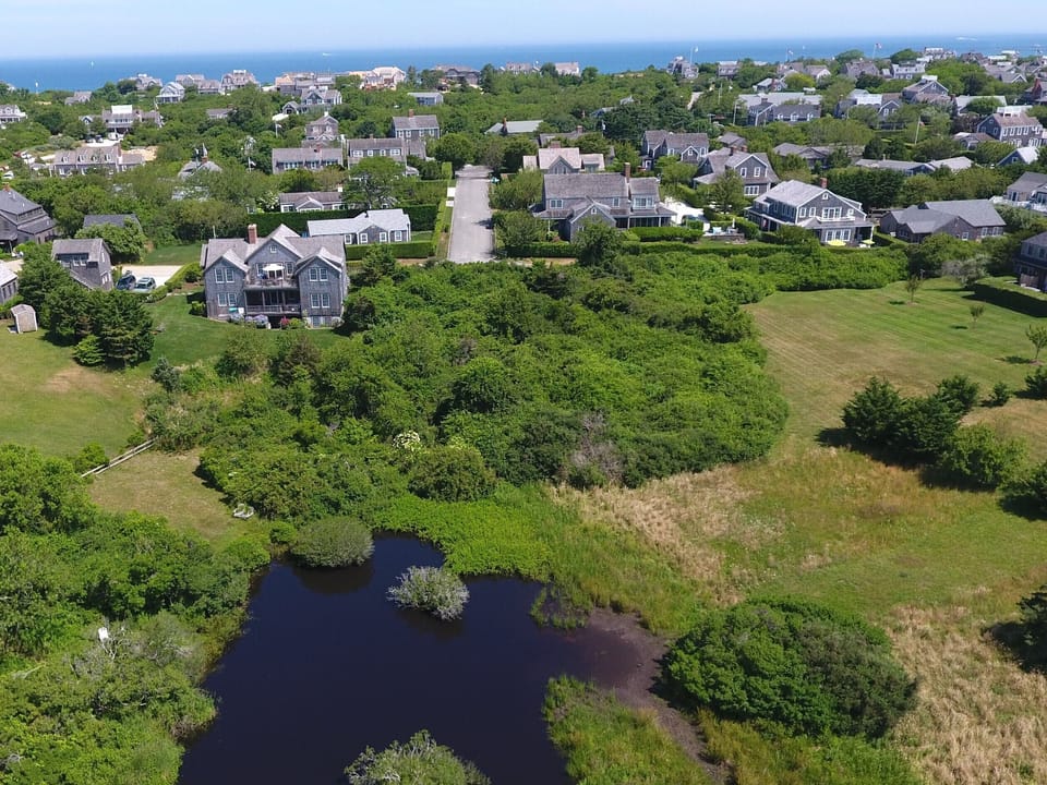 Aerial house view from abutting pond/conservation land with N. Sound in rear 