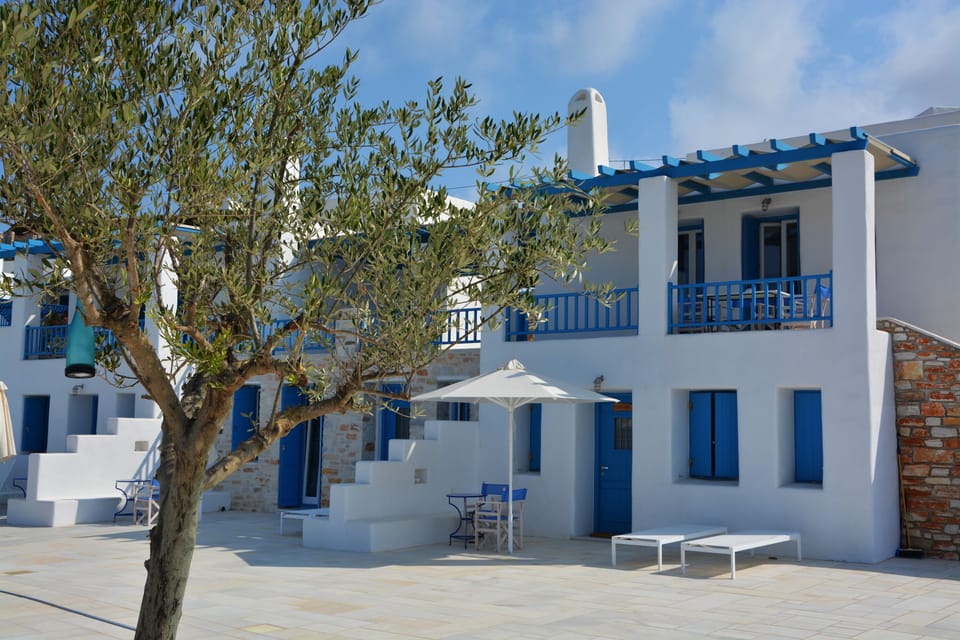 Private area out of the apartment with dining table, umbrella and sun beds