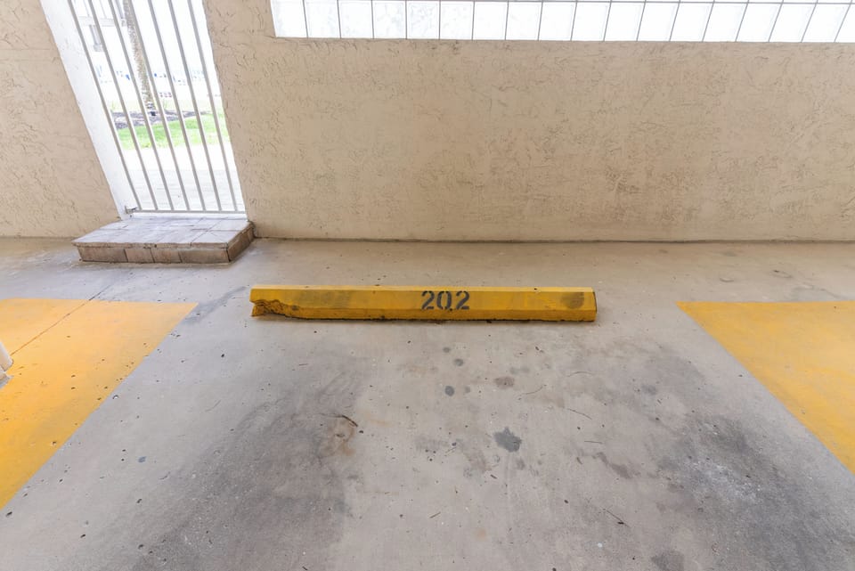 Private parking spots labeled unit 202 underneath parking
