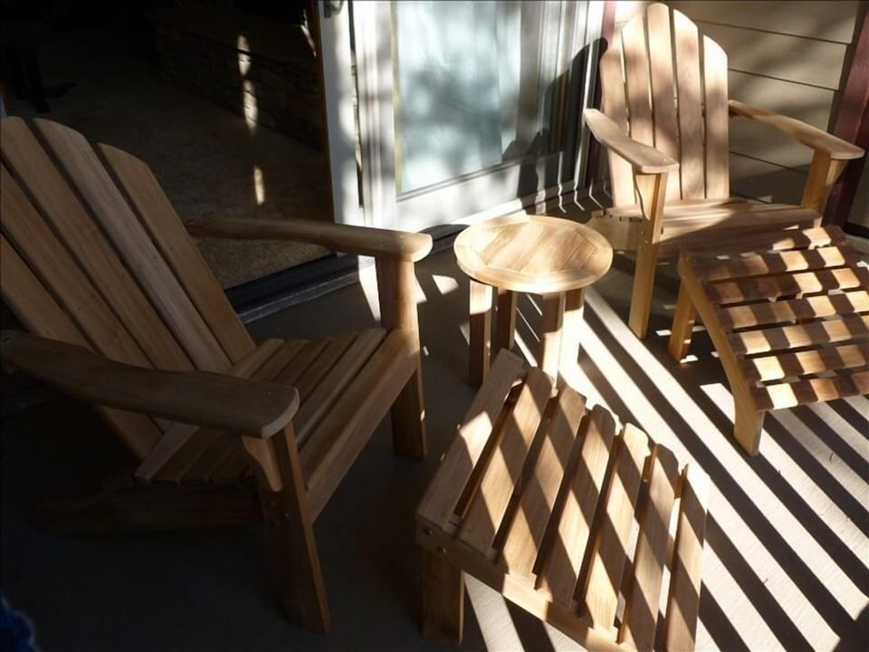 Teak Adirondack chairs on the patio facing the meadows