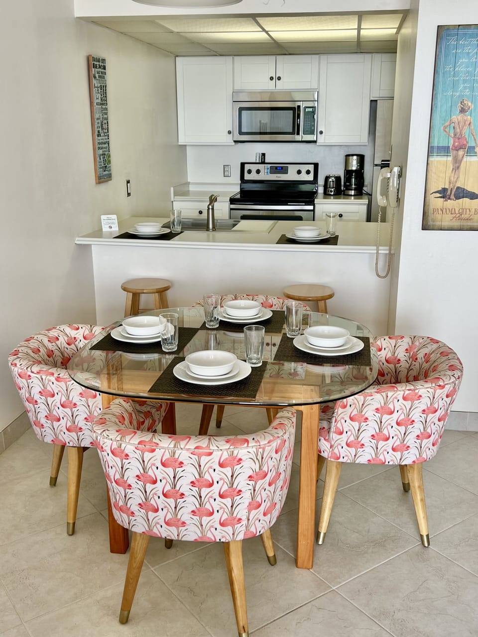 Dining room table with 4 settings, and 2 stools at counter.
