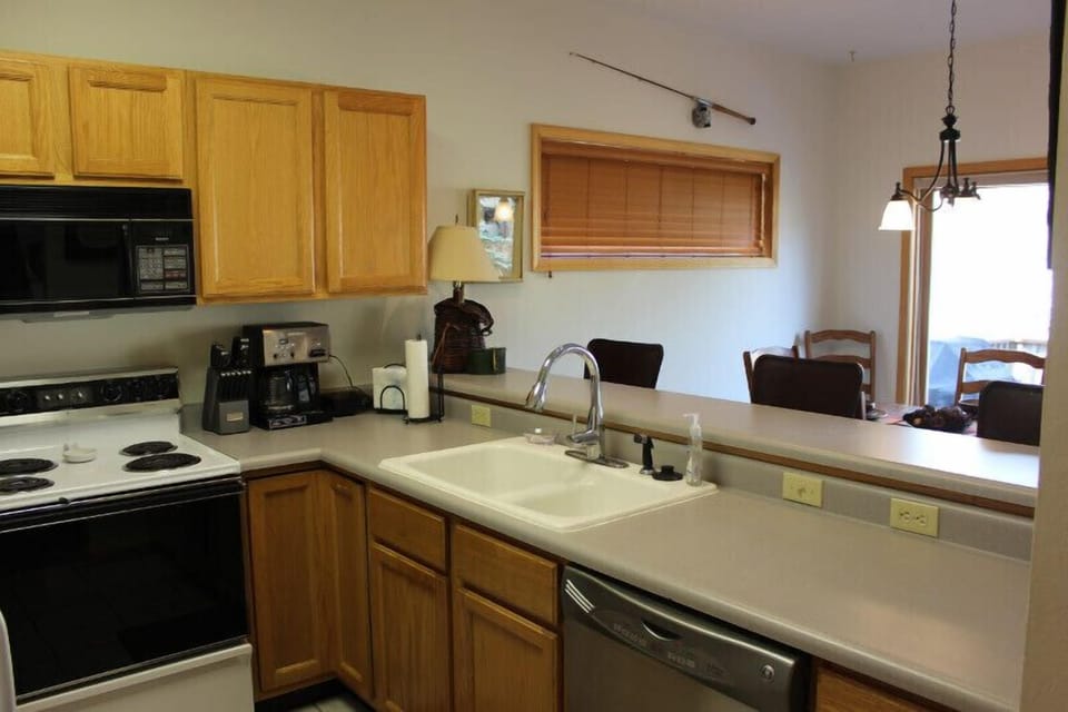 Kitchen and bar, looking into dining area.  Weber gas grill on deck, too.