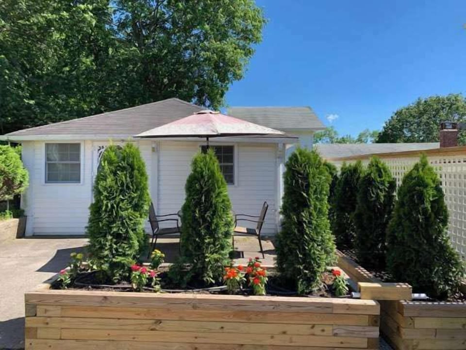 Landscaped front patio with seating area and BBQ grill access