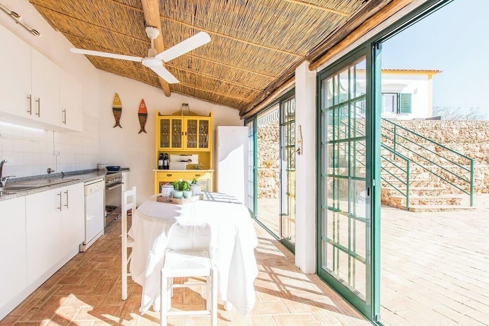 Bright open-plan kitchen with dining area and green terrace doors — Villa Rita, holiday villa in Silves