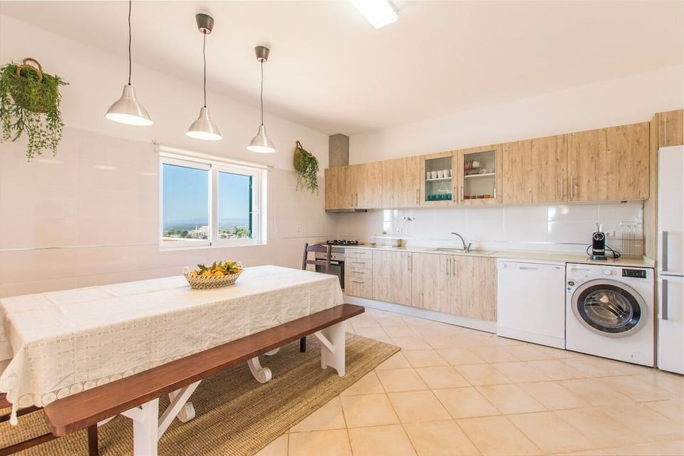 Bright open-plan kitchen and dining area with wooden cabinetry — Villa Rita, holiday villa in Silves