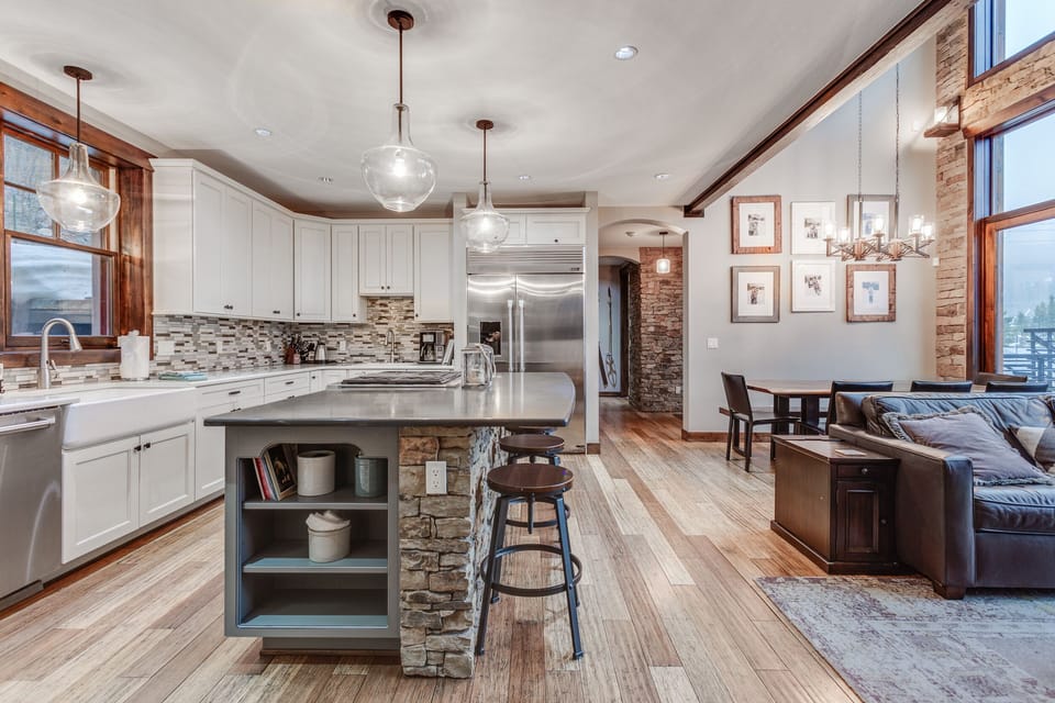 Well equipped gourmet chef's kitchen with modern high-end appliances, double ovens, massive fridge, and island seating for 4.