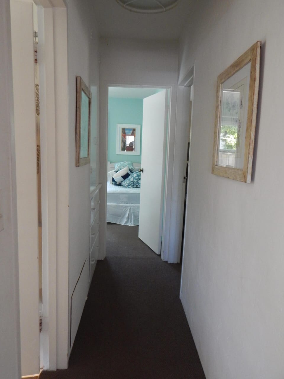 View from living area into hallway with bedrooms and bath