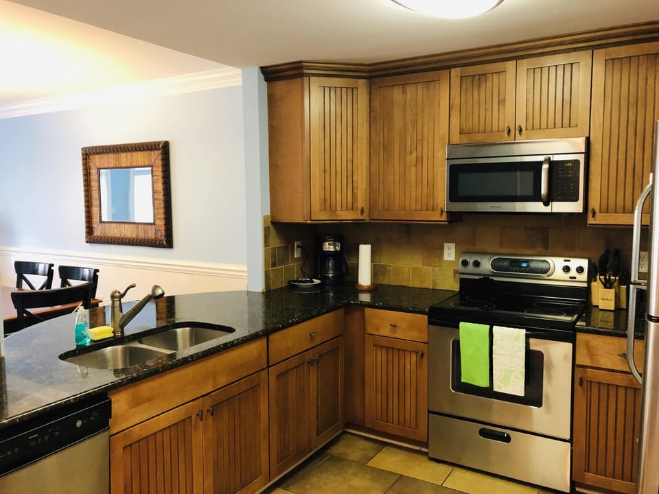 Fully-stocked, gourmet kitchen with granite counters and stainless appliances.