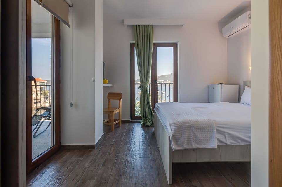 Room with flat screen TV , air conditioning and small refrigerator.