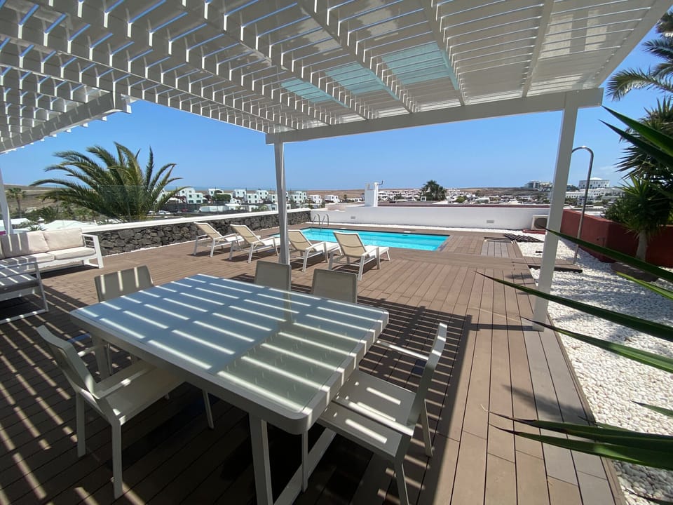 Al fresco dining: large table under the pergola on the terrace to enjoy the Canarian climate.
