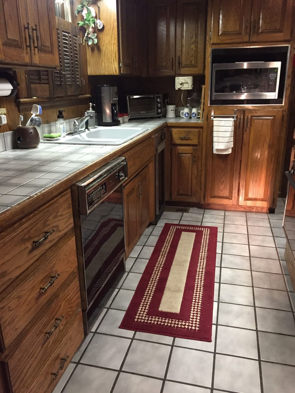 Kitchen view of large counter, double sink, dishwasher and microwave