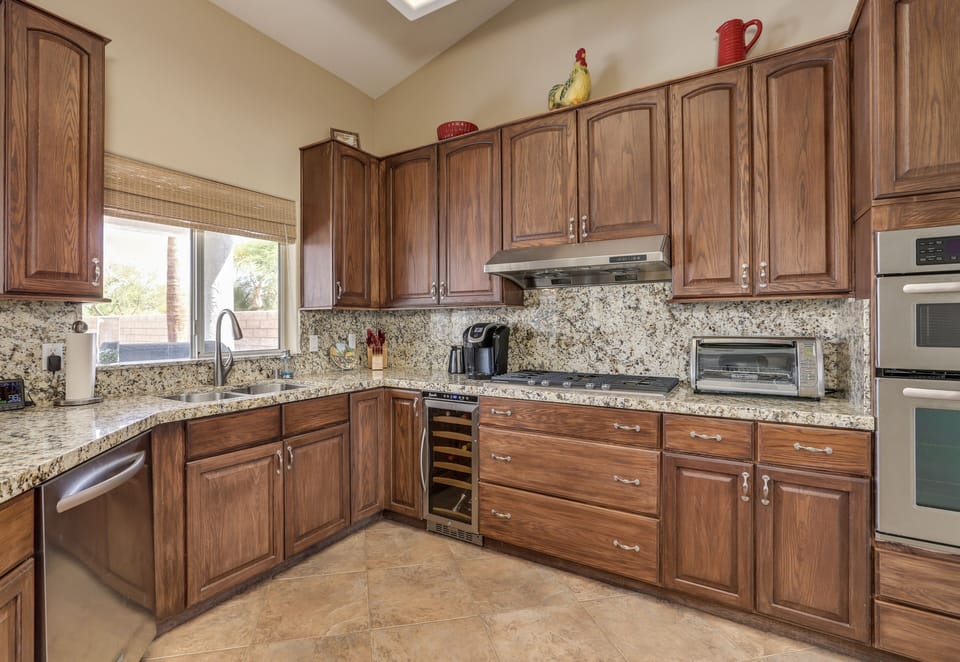 Kitchen equips with Keureg coffee maker, toaster over, stainless appliances