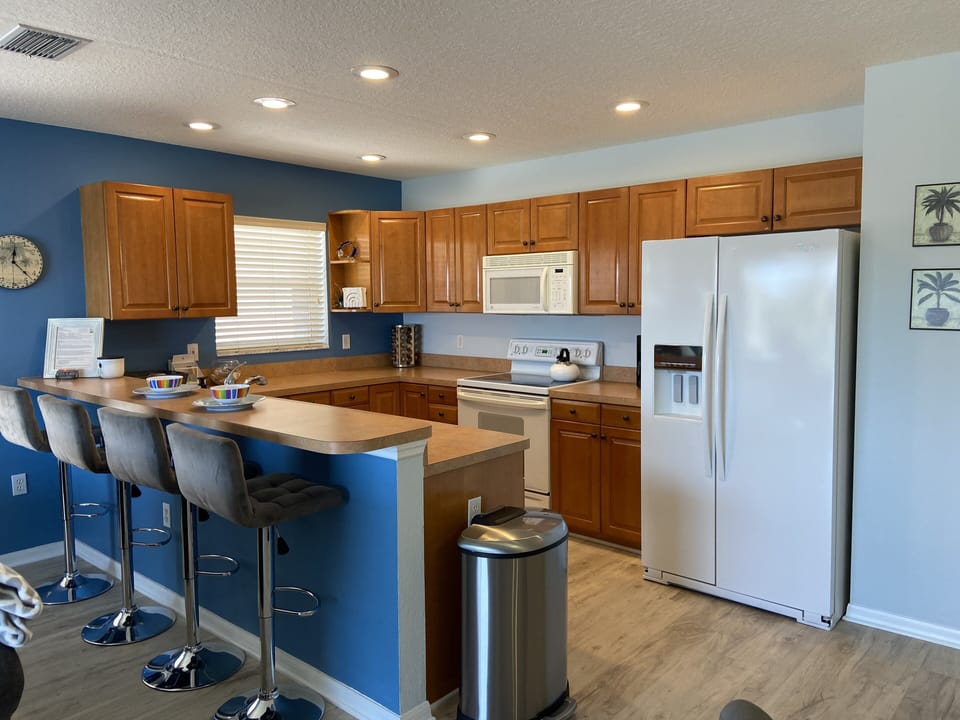 Open kitchen with dishwasher, oven/stove, microwave and fridge with icemaker