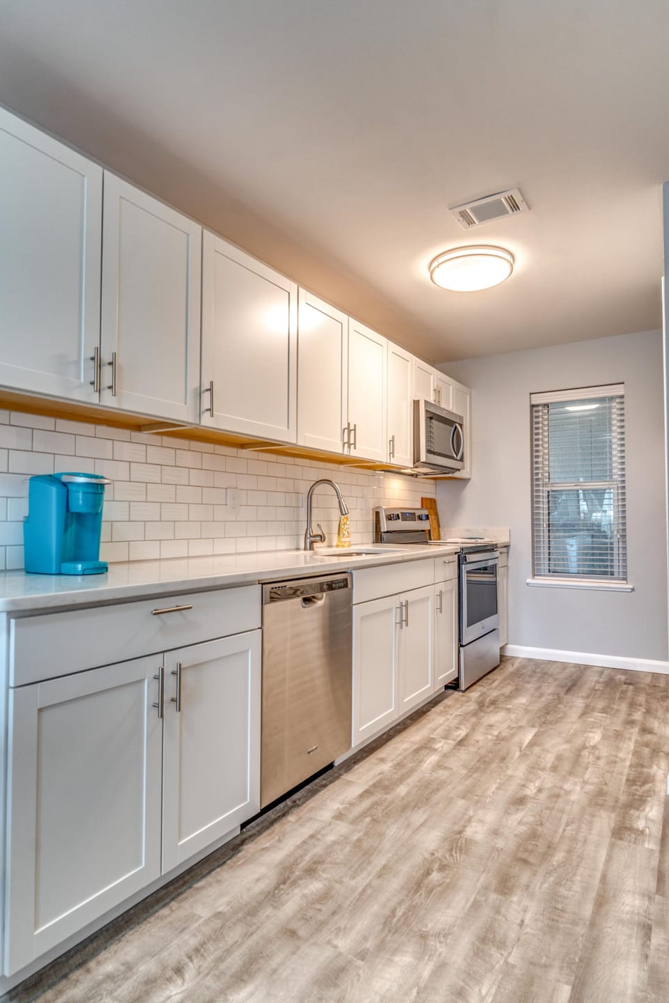 Stocked kitchen with quartz countertops, stainless steel appliances, and Keurig 